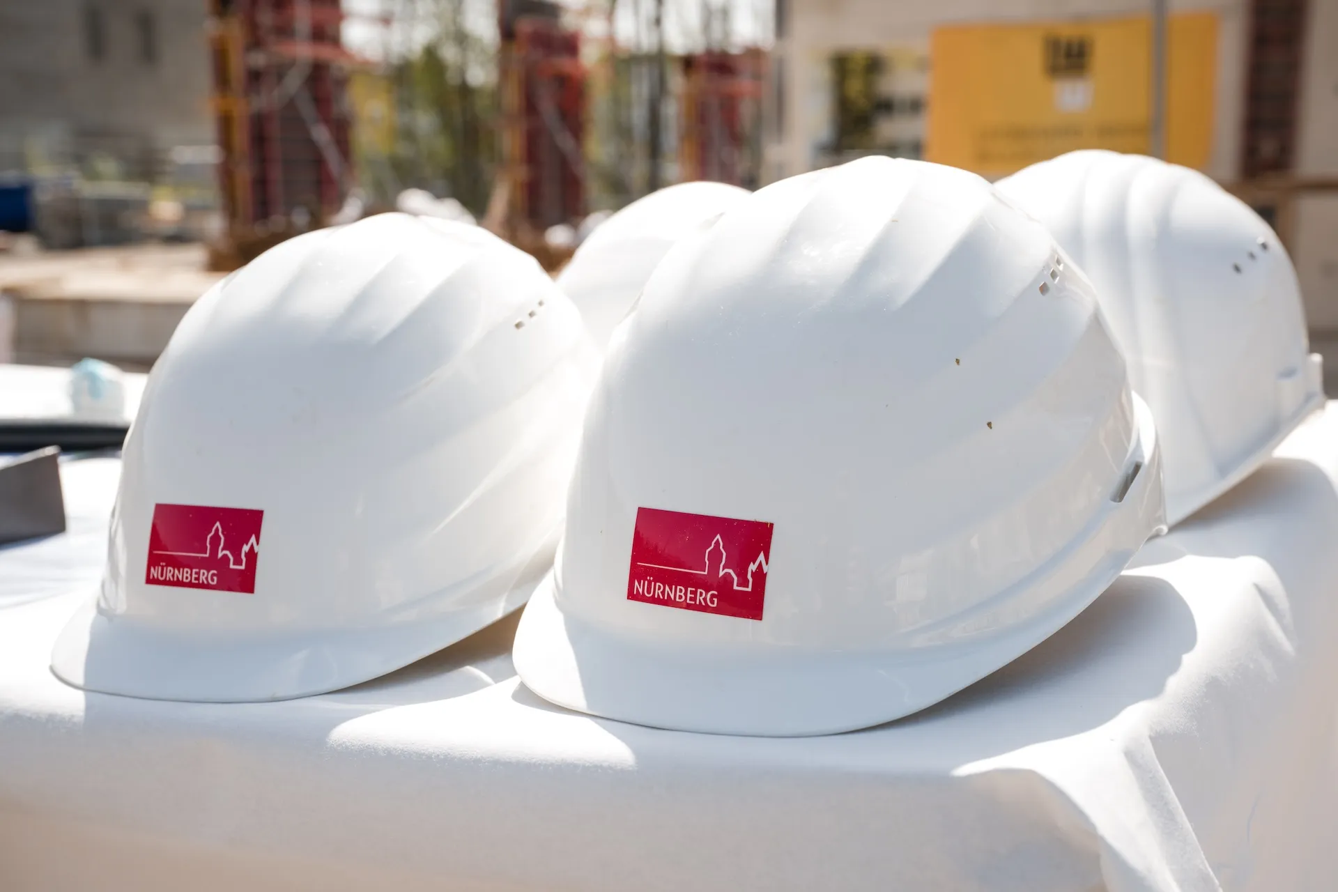 Weiße Bauhelme vor Nürnberger Skyline