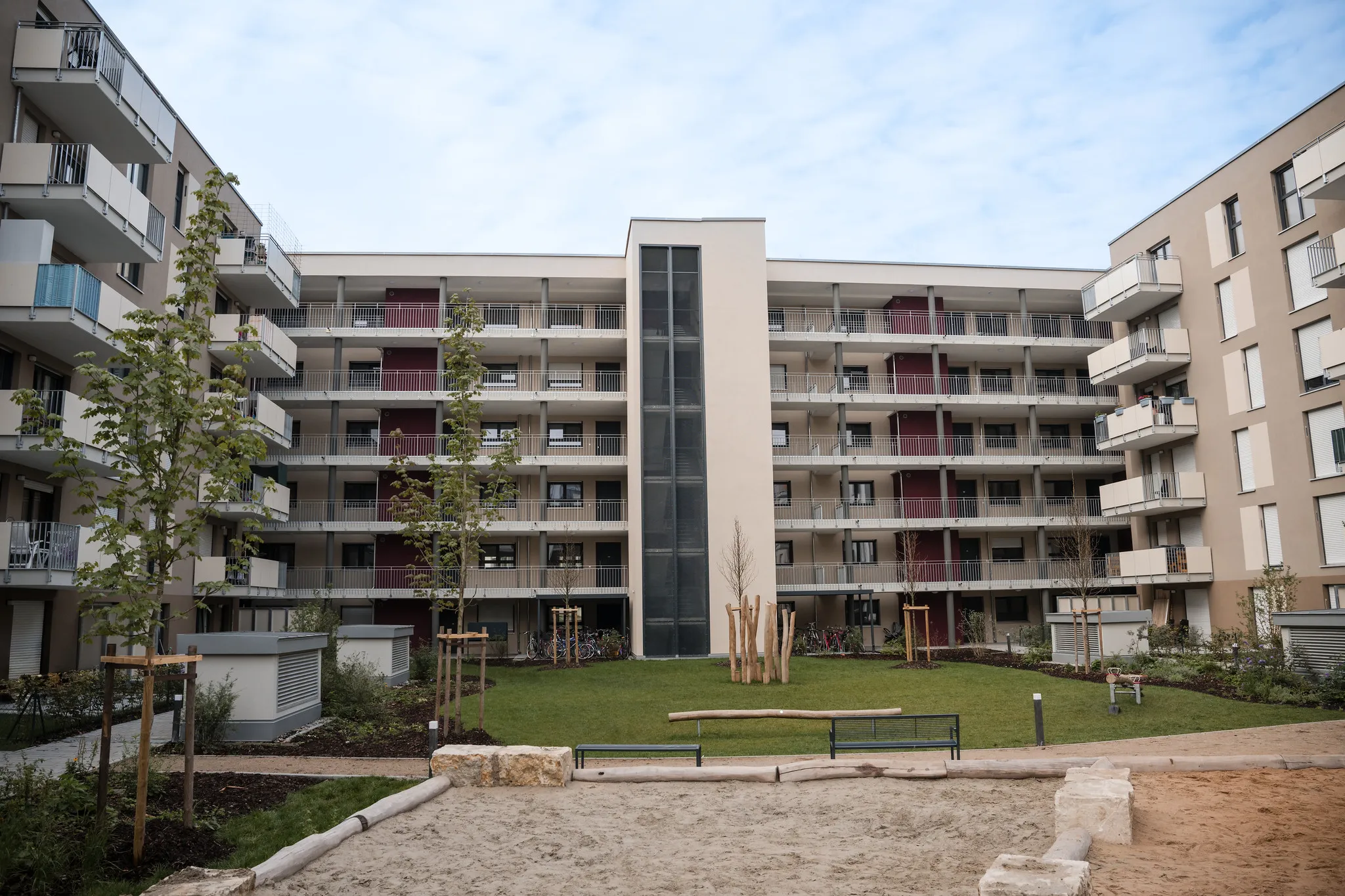 Begrünter Innenhof einer Wohnanlage mit Spielplatz und Balkonen, Immobilienfotografie Nürnberg.