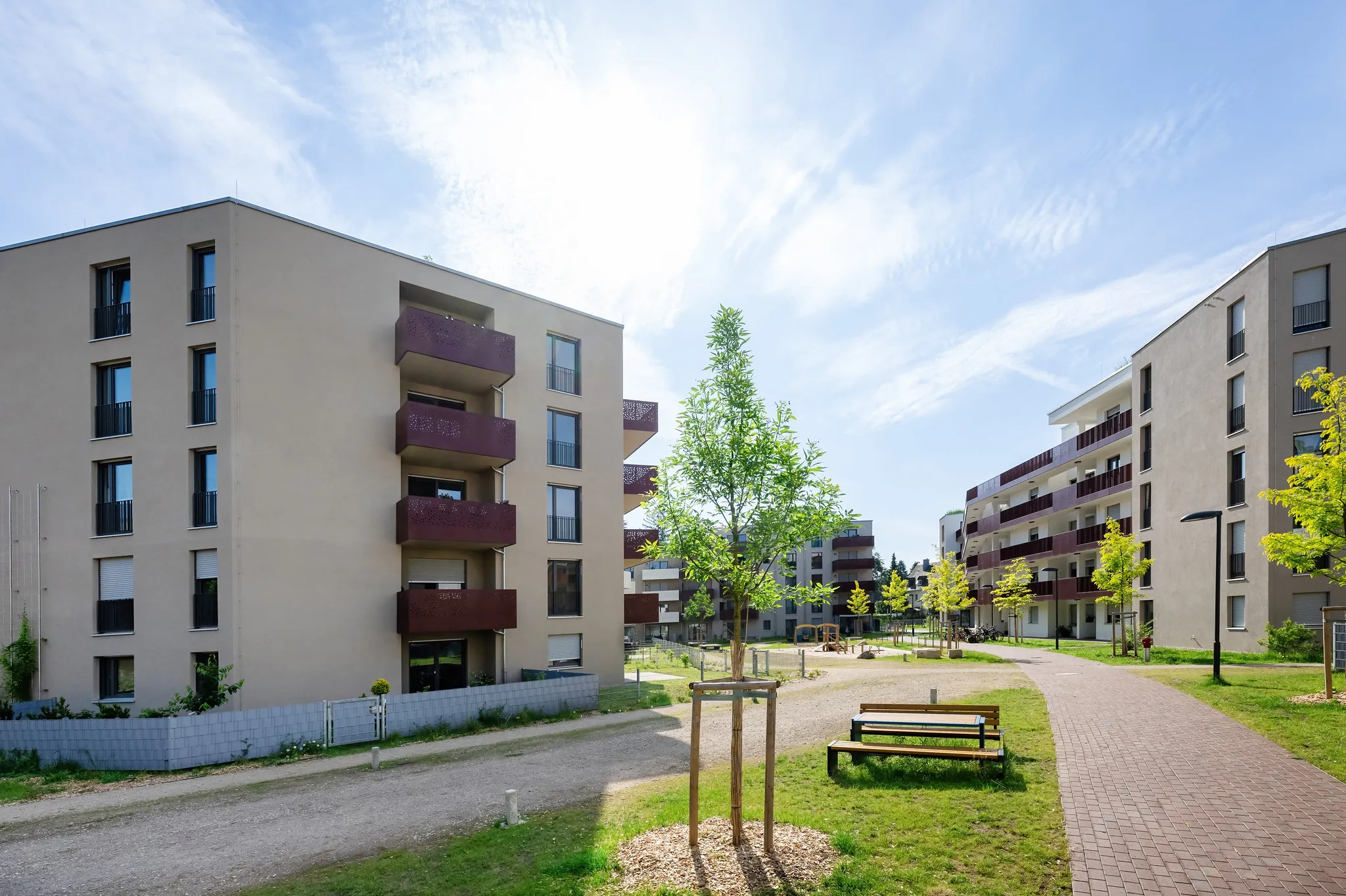 Wohnquartier mit Innenhof, Wegen und Sitzbänken.