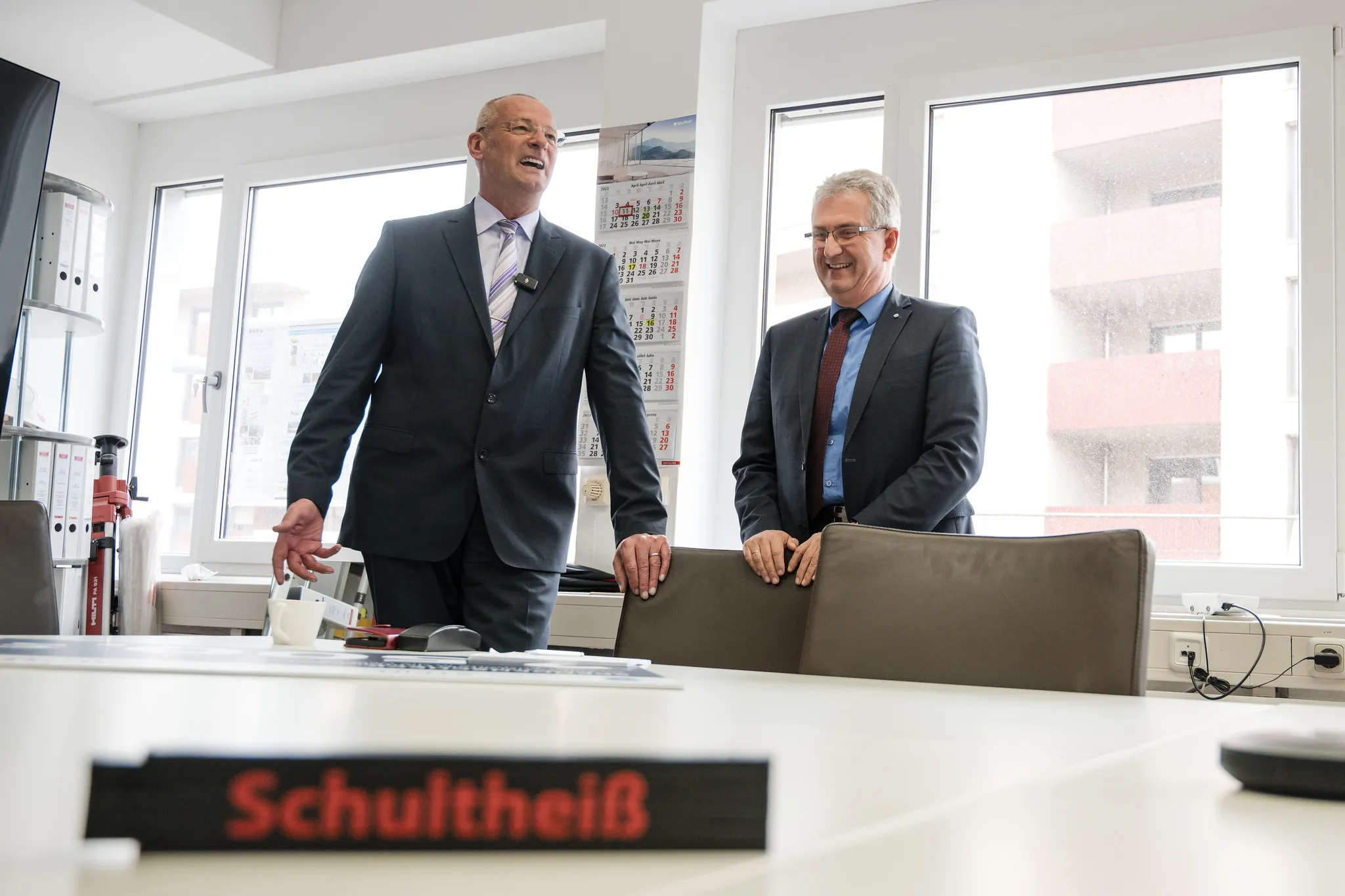 Zwei Geschäftsführer im Anzug lachen im Büro, lebendiges Business-Portrait im mobilen Studio vor Ort
