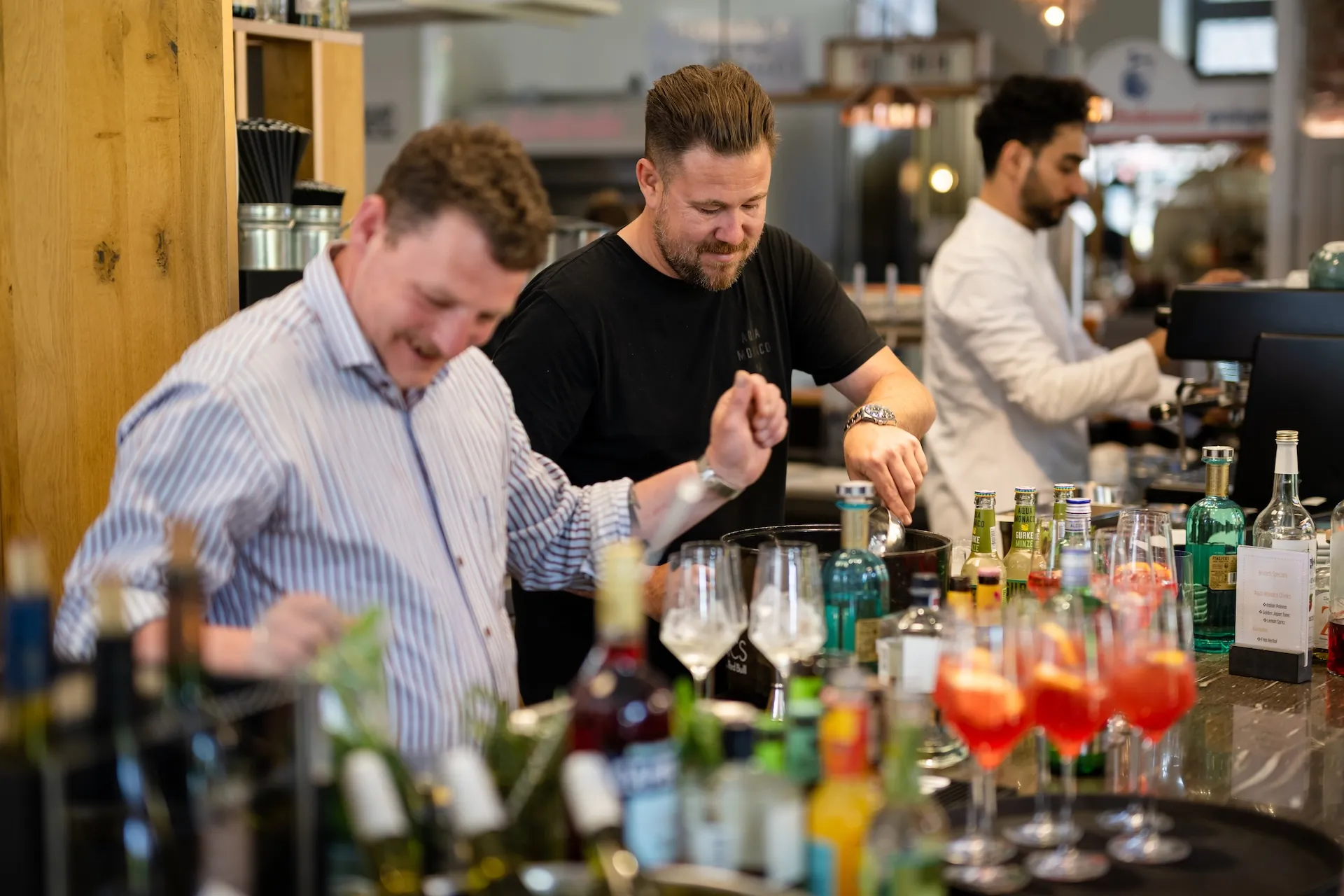 Zwei Männer mixen Cocktails an der Bar, Barkeeper in Aktion.