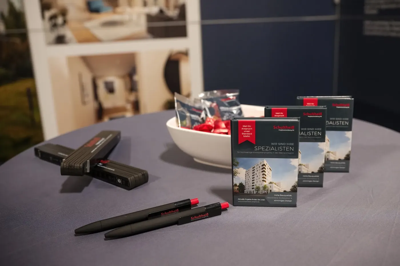 Promotional material and brochures on a table at a trade fair booth, detail shot