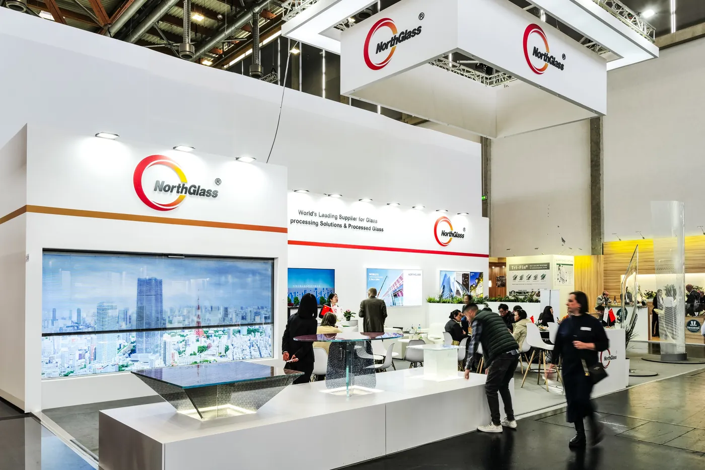 Bright booth with a large image wall and visitors