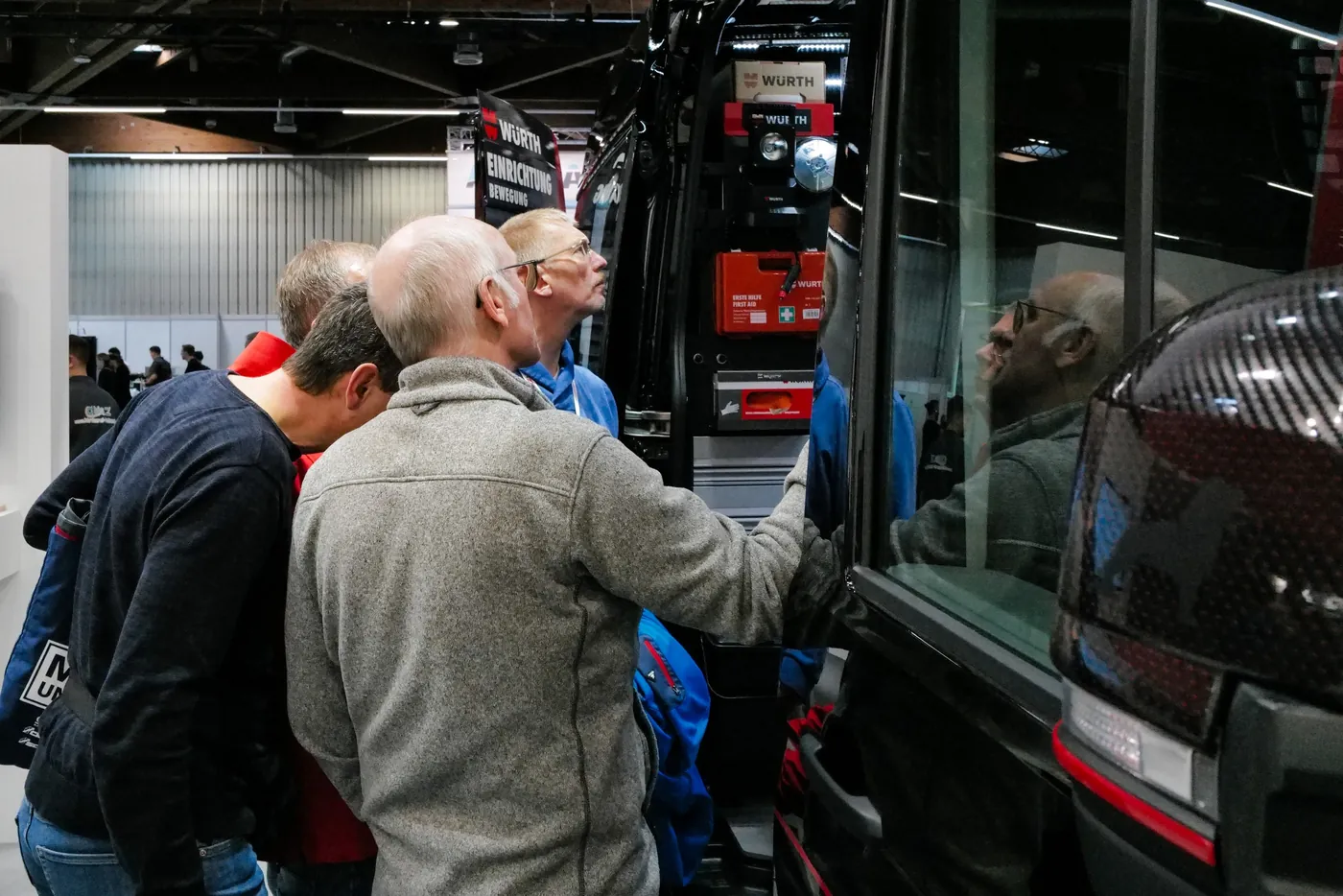 Trade visitors inspecting a machine at a booth