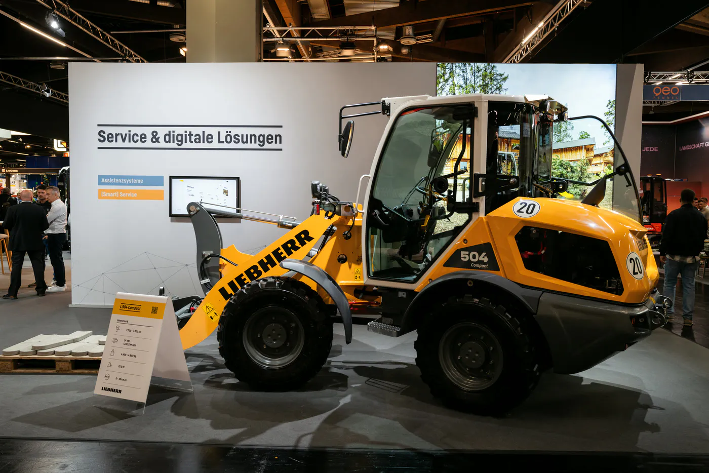 Cleanly lit Liebherr exhibition stand with wheel loader and brand wall at GaLaBau in Nuremberg