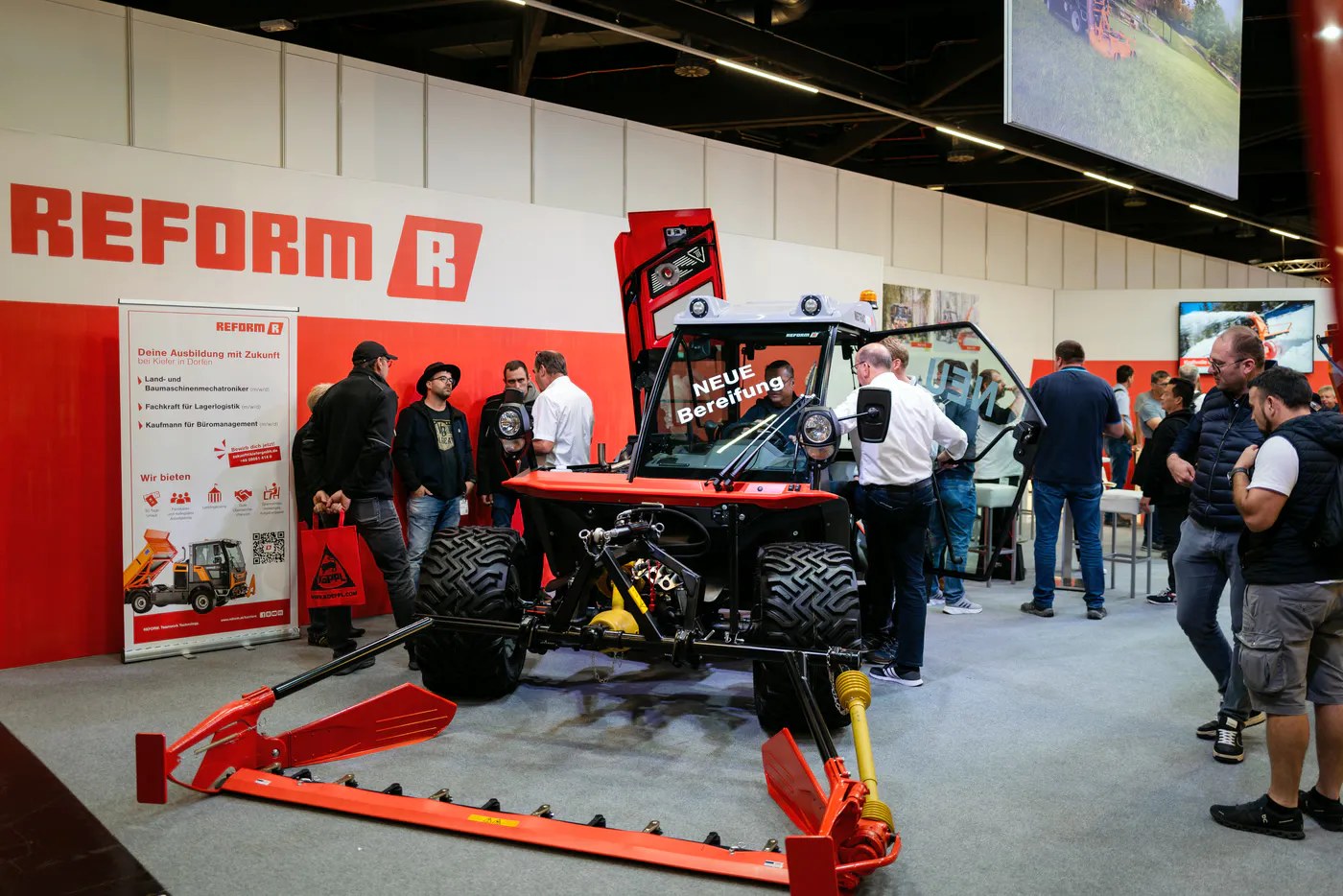 Red Reform brand stand with implement carrier and trade visitors at GaLaBau in Nuremberg