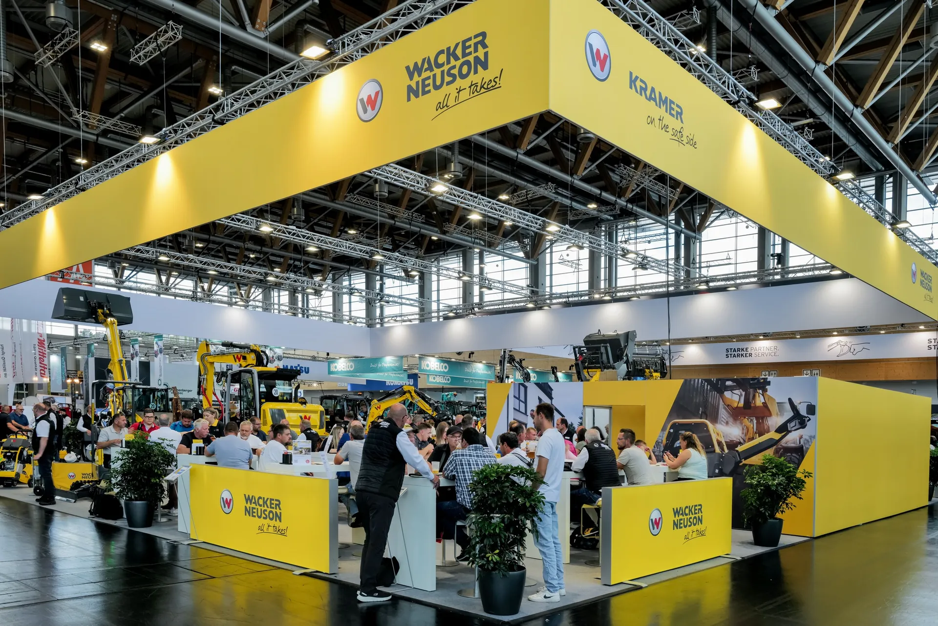 Yellow brand booth with machines and many visitors