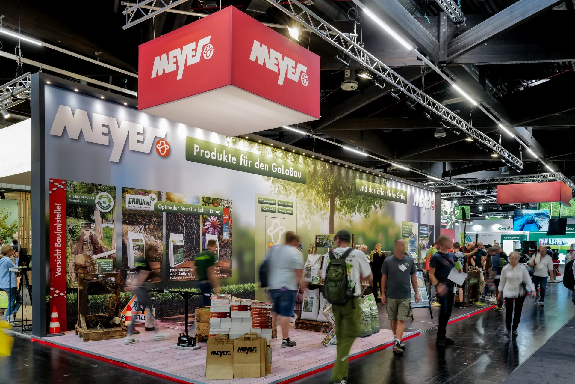 Large brand booth with red hanging signs and product wall