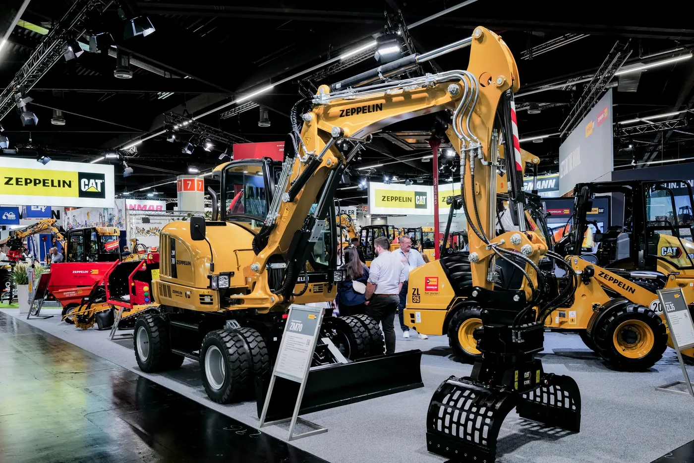 Wheel loader and wheeled excavator as exhibits at a booth