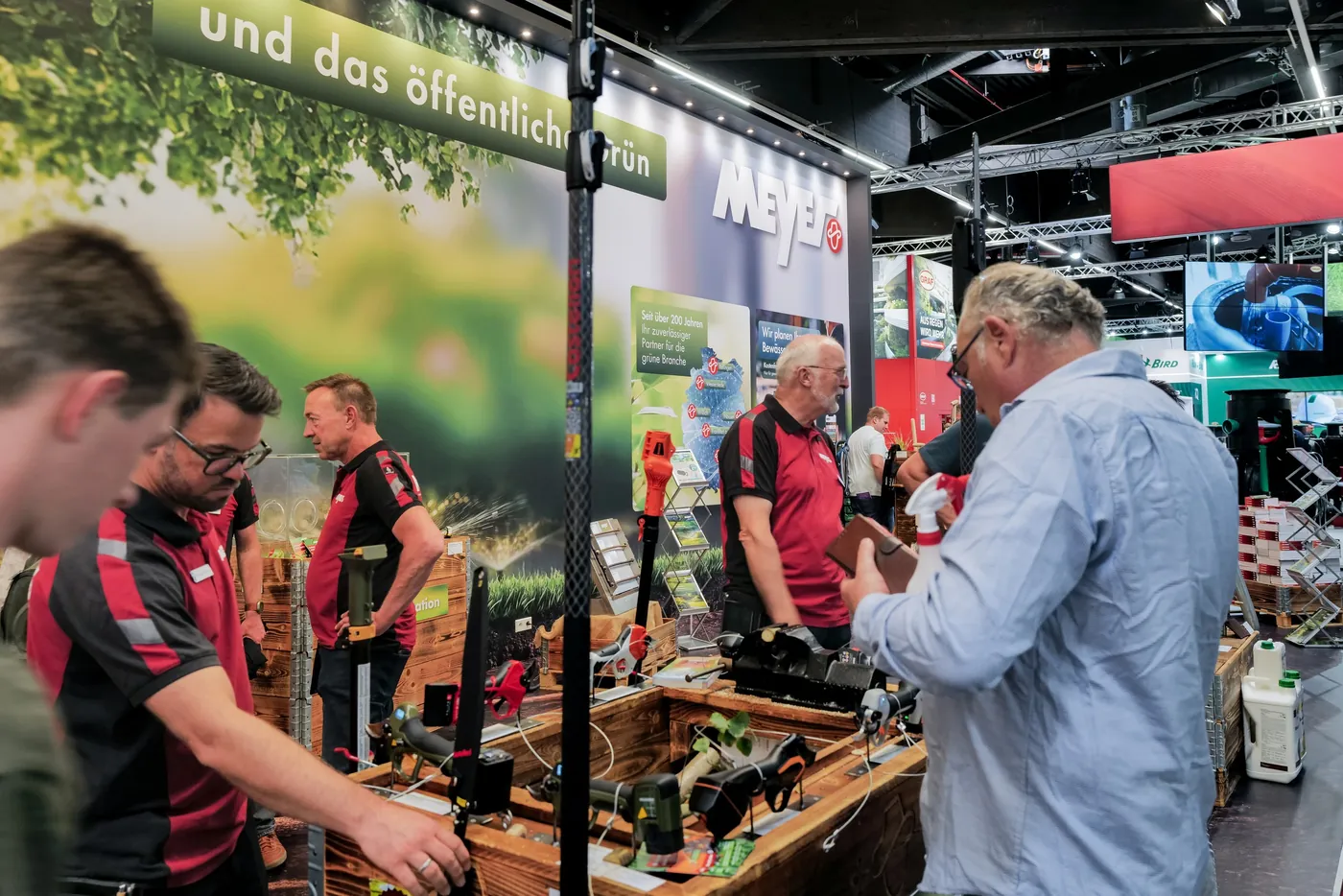 Booth team in conversation with a visitor at a product table