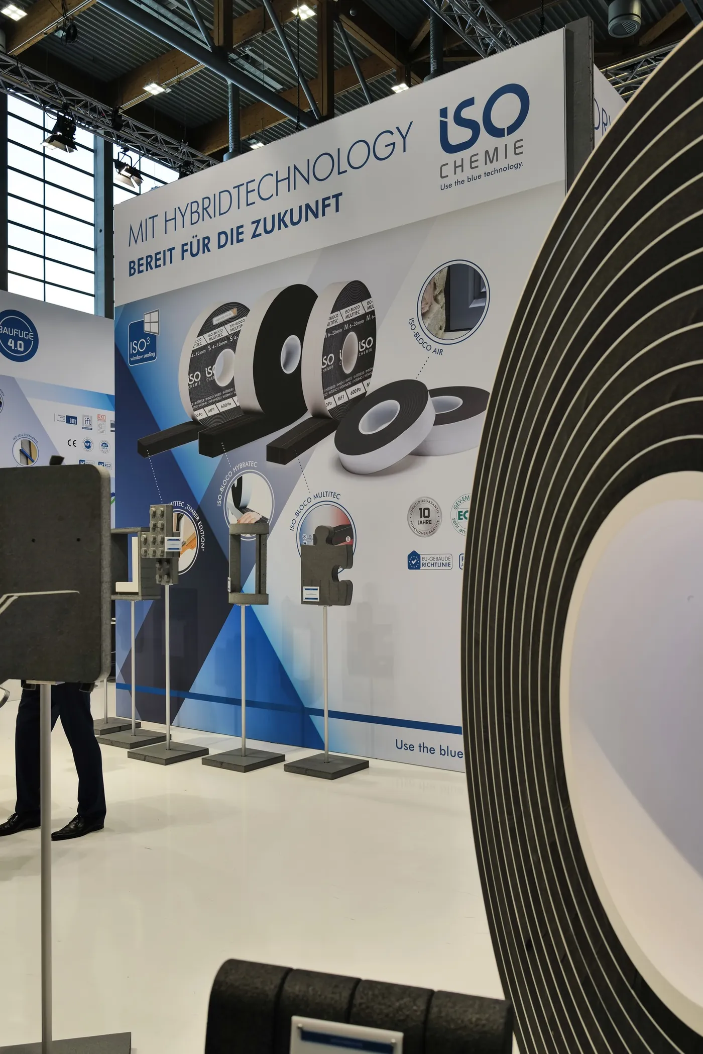 Messestand mit Beschlag-Exponaten an einer grafischen Wand