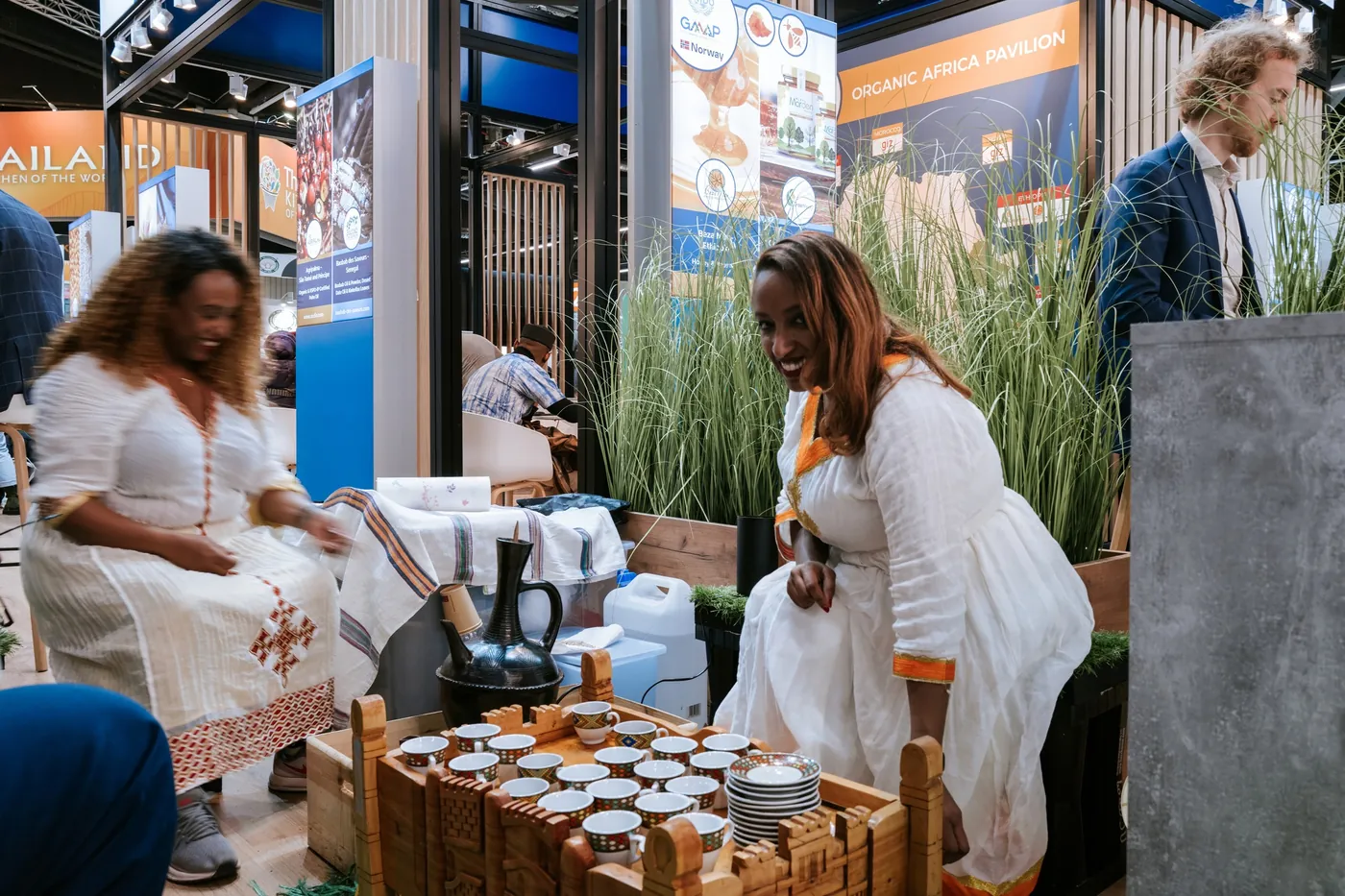 Ausstellerinnen in weißen Kleidern präsentieren Produkte auf der BIOFACH in Nürnberg