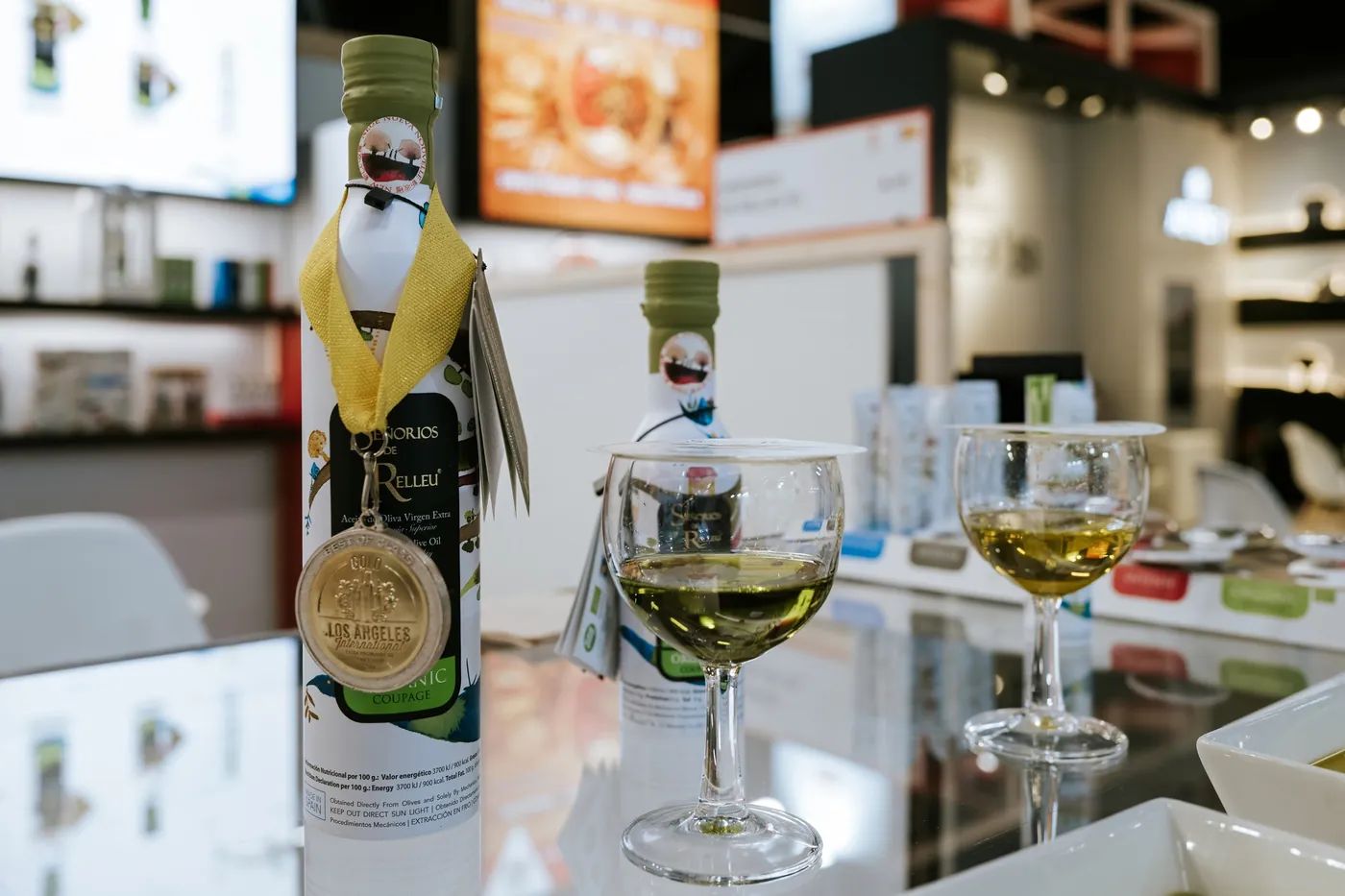 Weingläser und Olivenöl auf einer Glastheke an einem Stand der BIOFACH in Nürnberg