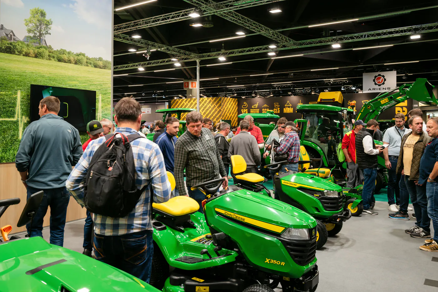 Publikum am John-Deere-Messestand mit grünen Aufsitzmähern auf der GaLaBau in Nürnberg