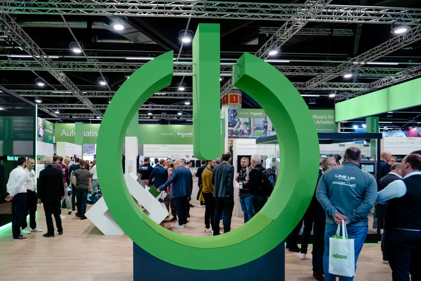 Großes Markensymbol als Standeingang mit Besuchern