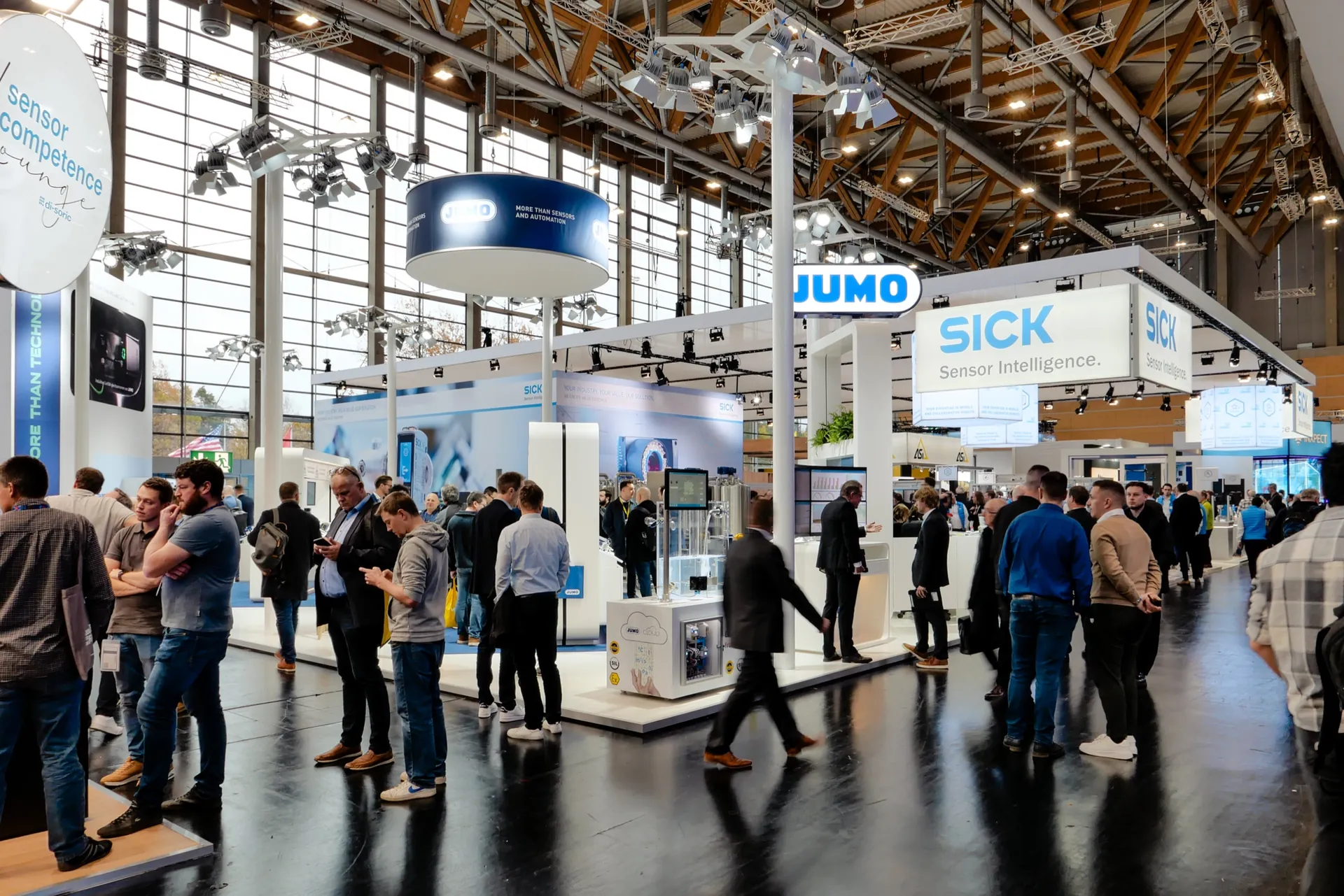 Hallengang mit Messeständen und Besucherströmen